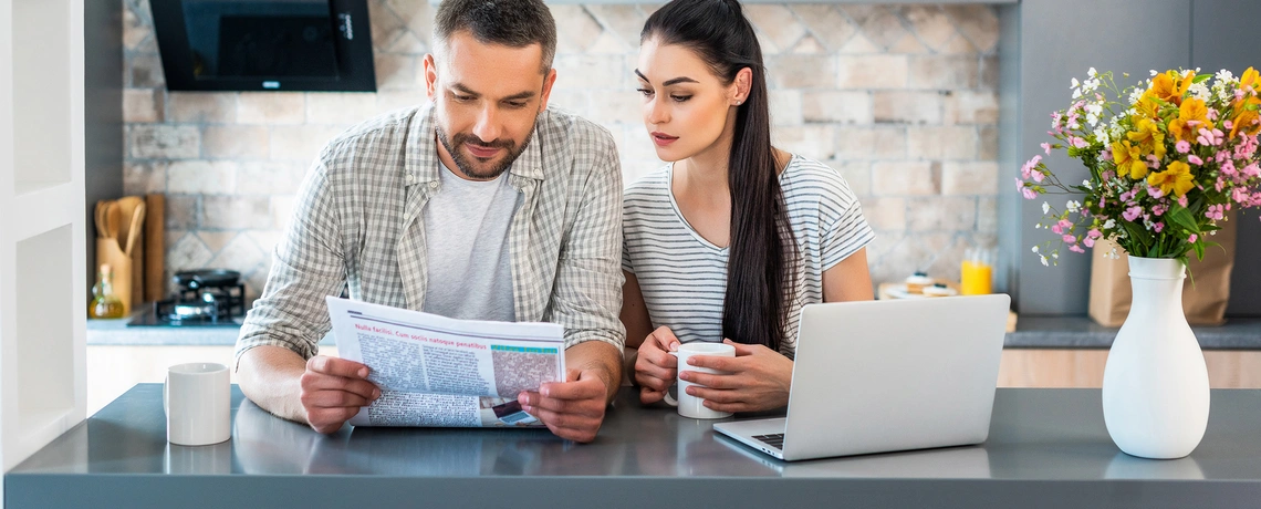 Paar liest gemeinsam die Zeitung analog und digital