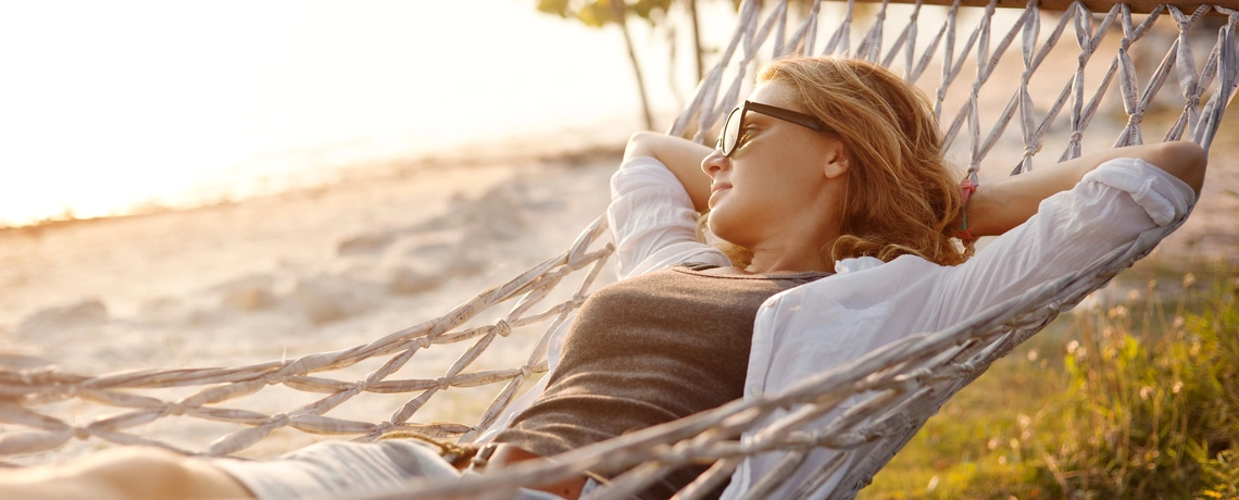 Frau in Händematte am Strand